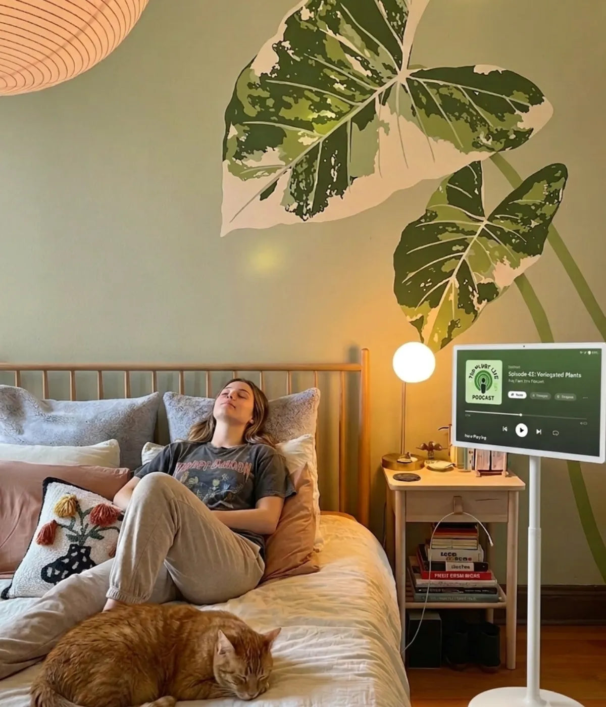 A girl is relaxing in bed, accompanied by music playing on her GFF portable TV on wheels