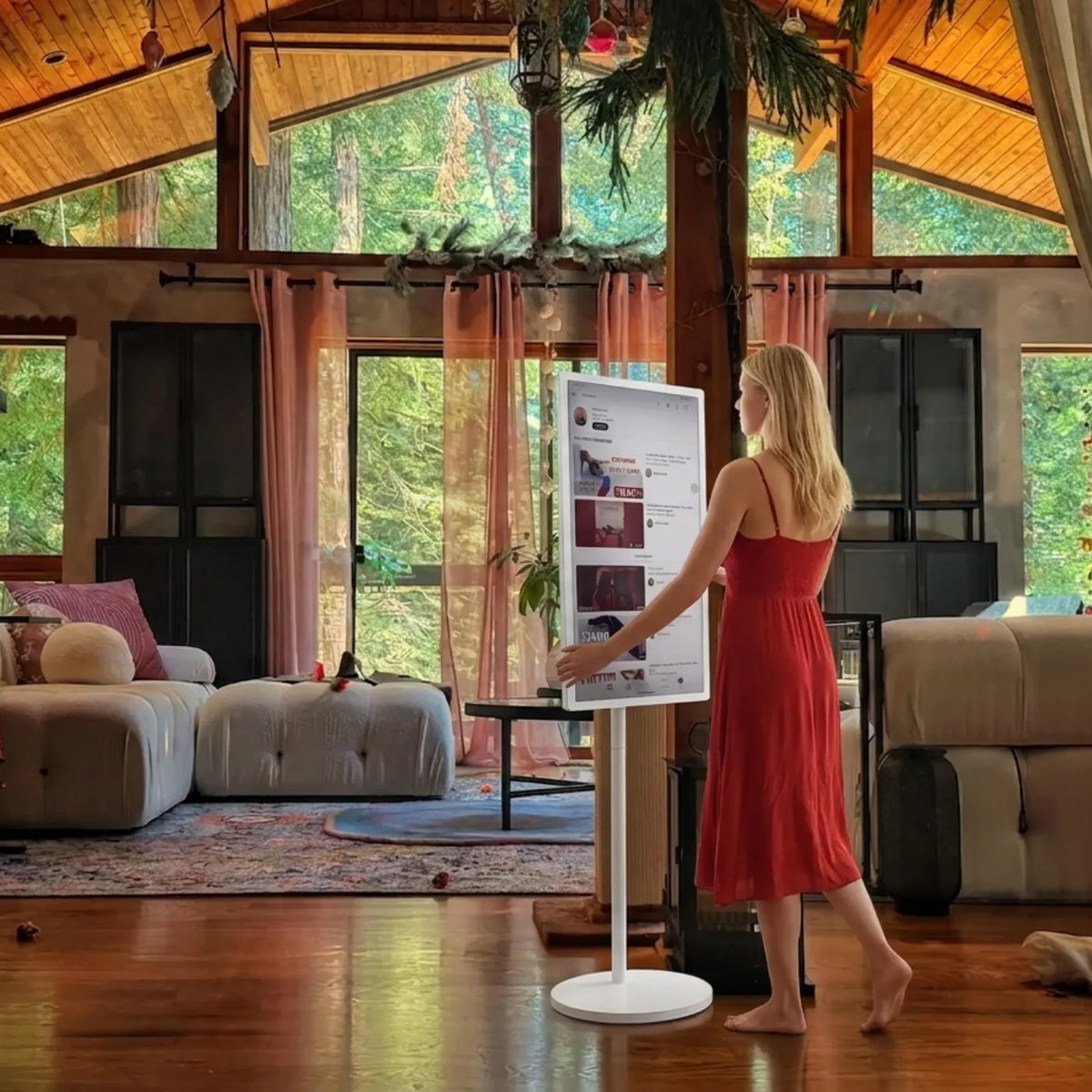 A woman moves through the living room, rolling her GFF portable TV along with her