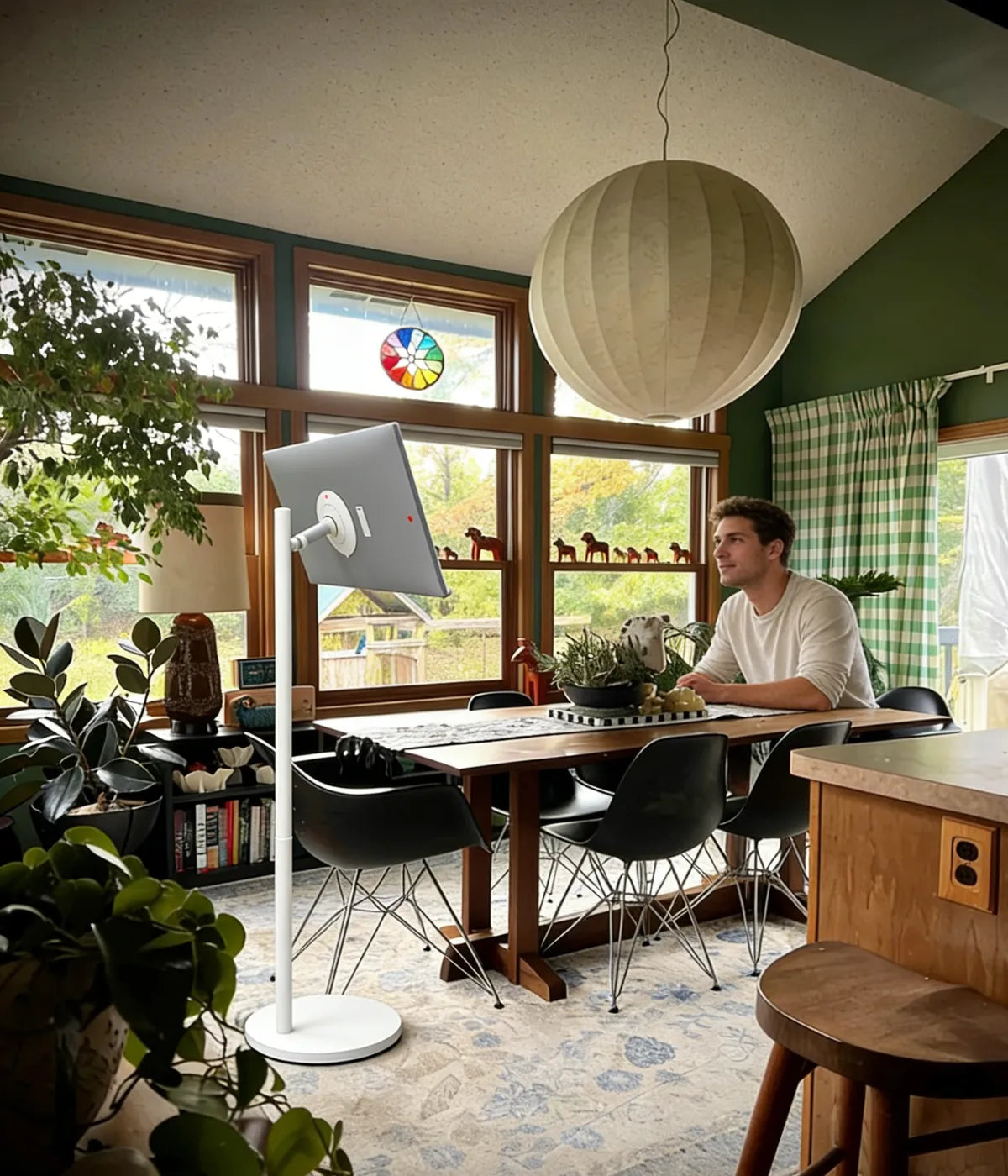 a man watching football with GFF AI portable TV on wheels